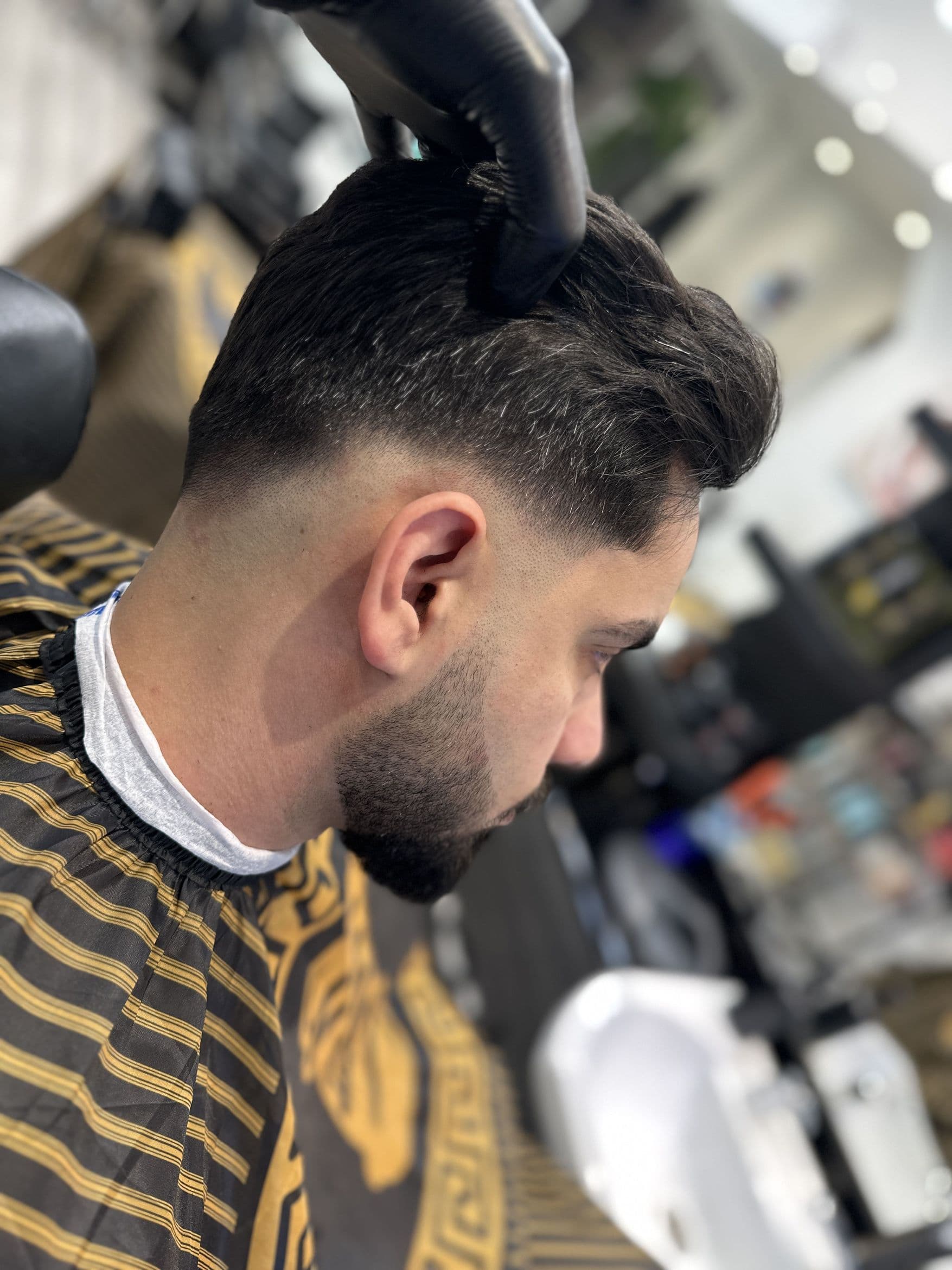 Sharp side fade with textured styling at KD Barbers